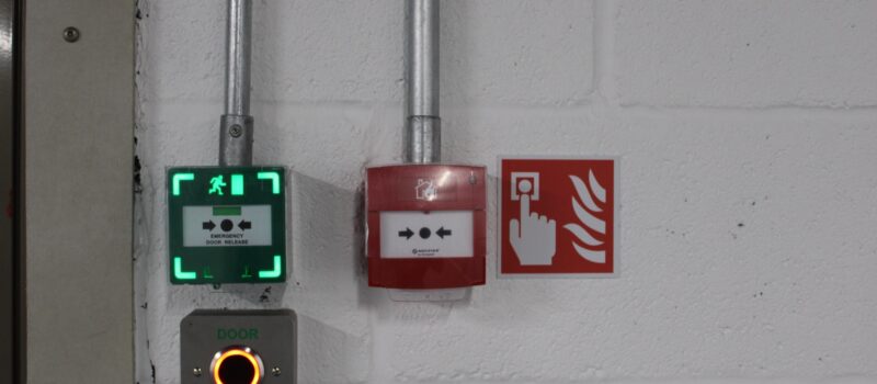 Closeup Of Fire Alarm And Emergency Door Release - Surrey Tech Services